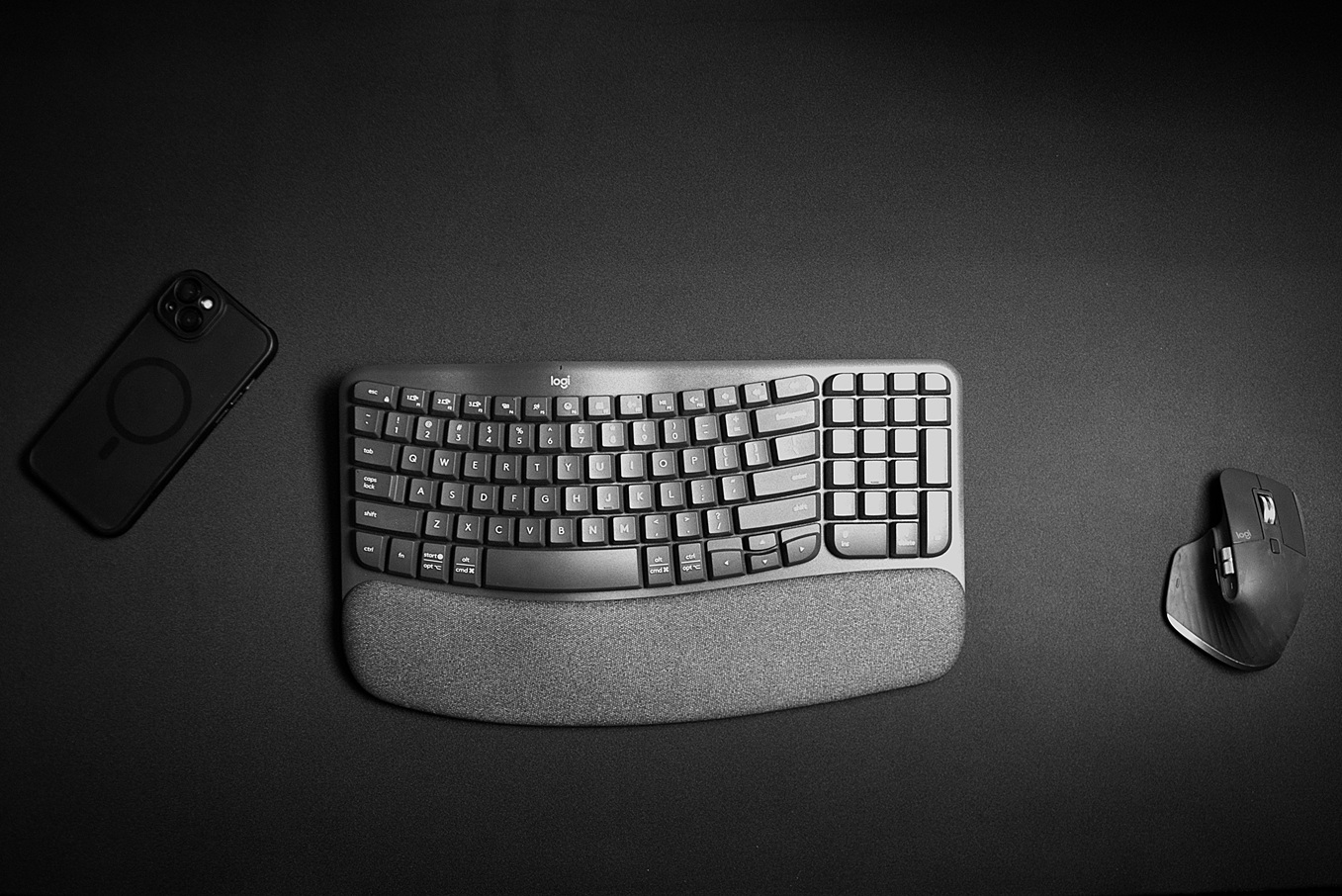 Logitech wireless keyboard and mouse on a black fabric gaming desk mat