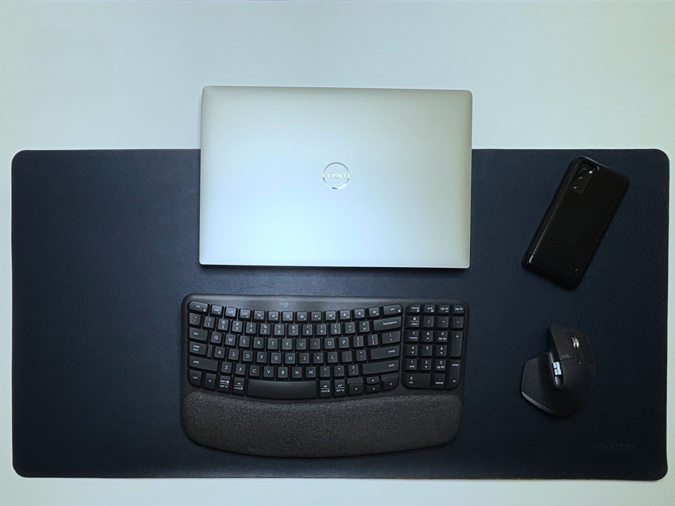 Dell XPS, Logitech wireless mouse and keyboard on a blue colored professional desk mat