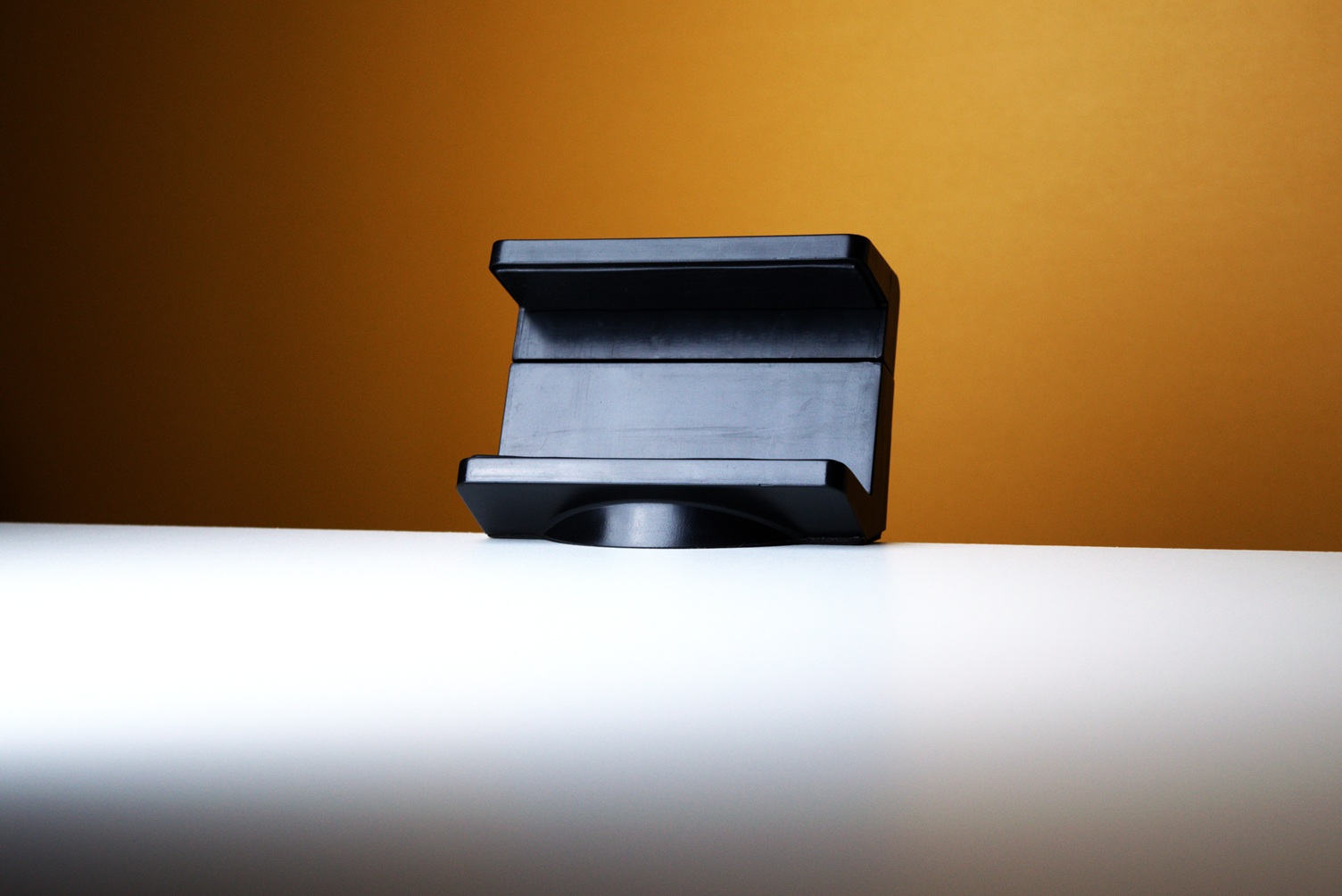 Black power strip holder mounted to a white desk