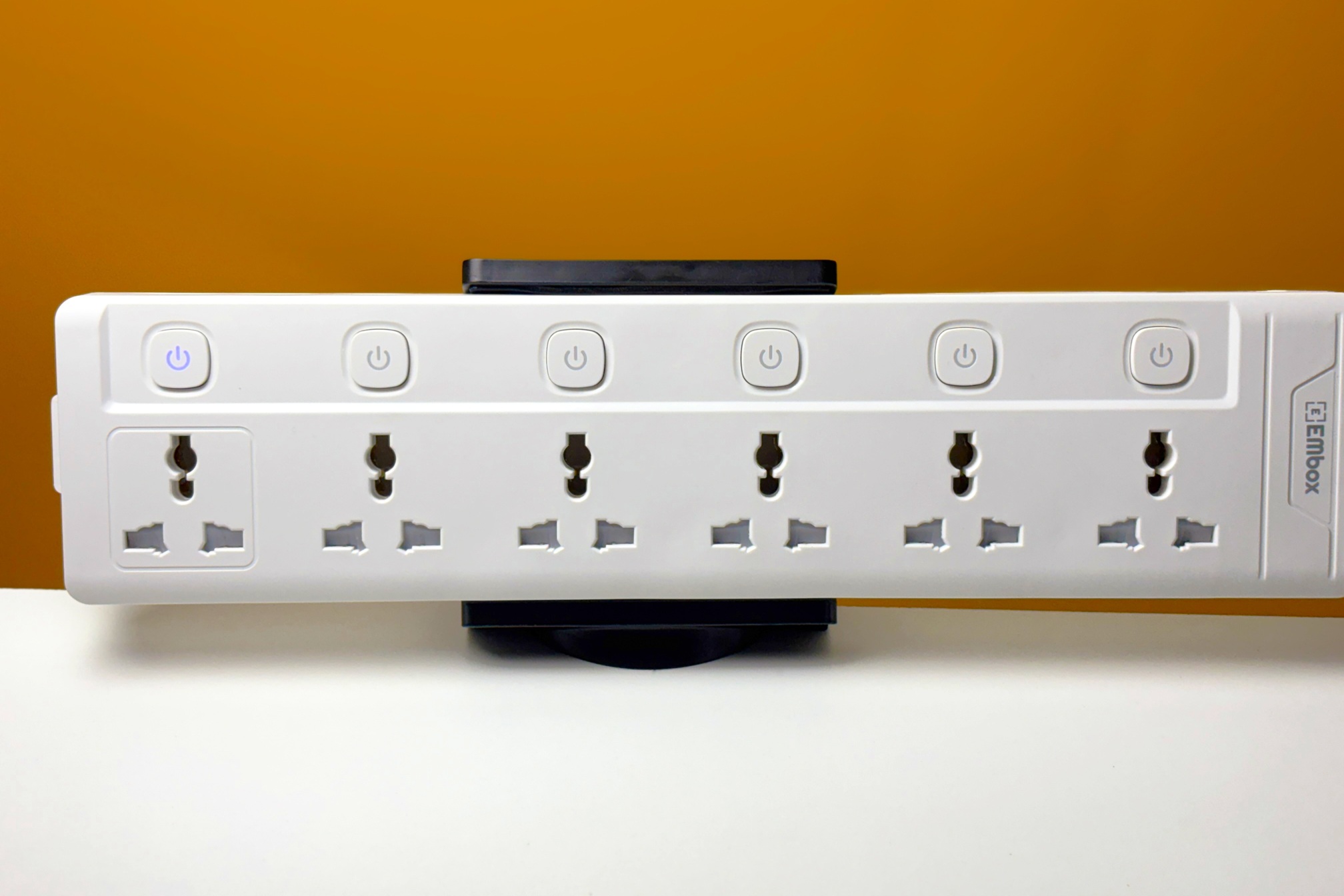 Empty power strip mounted to a desk using a power strip holder