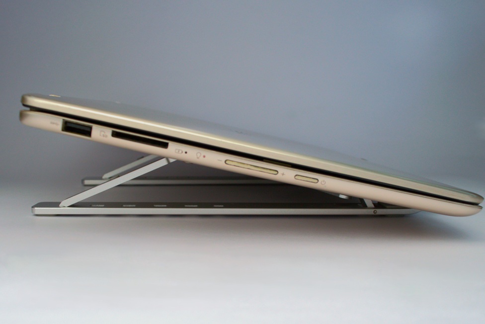 Closed Asus UX360CA laptop on a metallic laptop stand