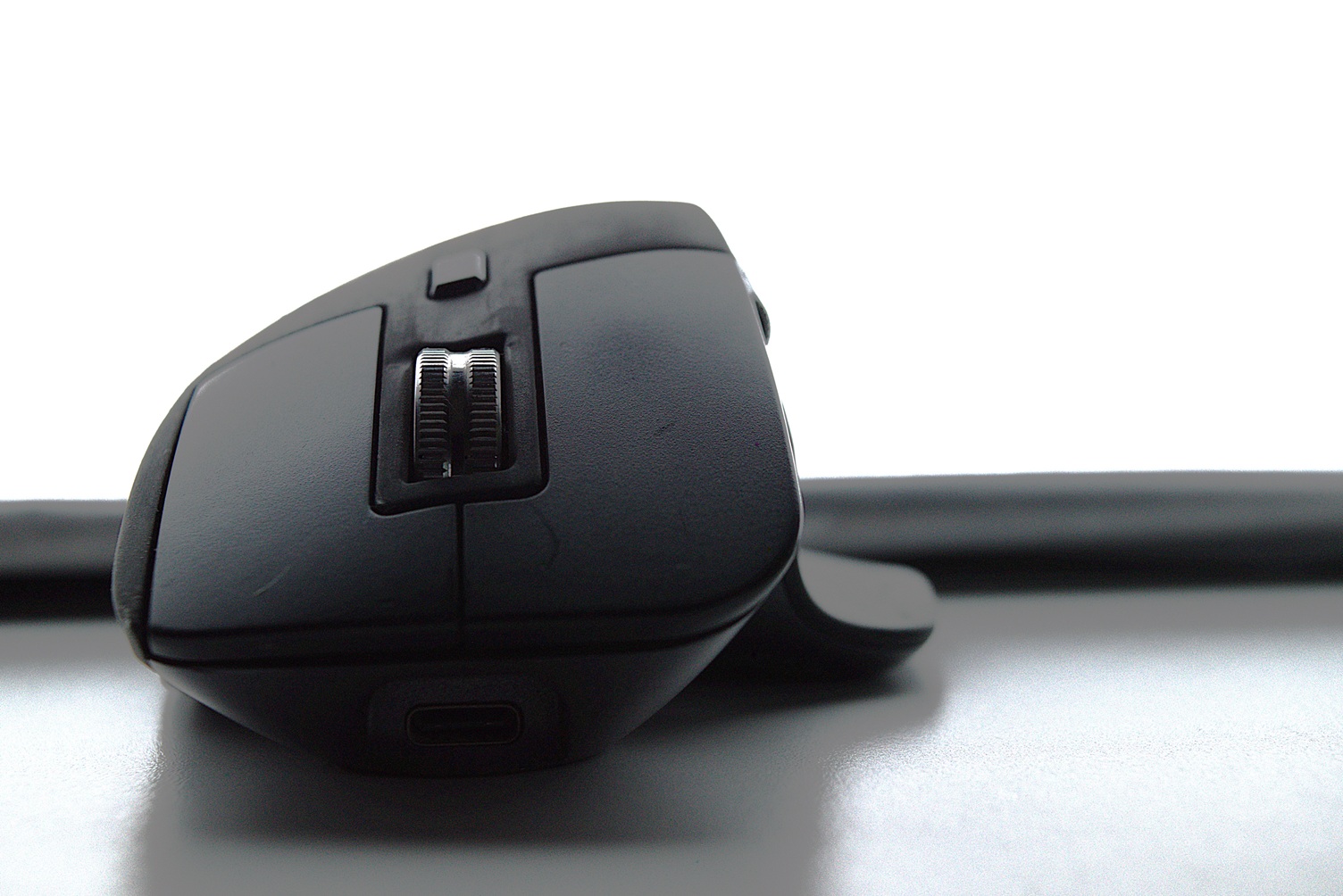 Front side of a black MX Master 3 on a white desk