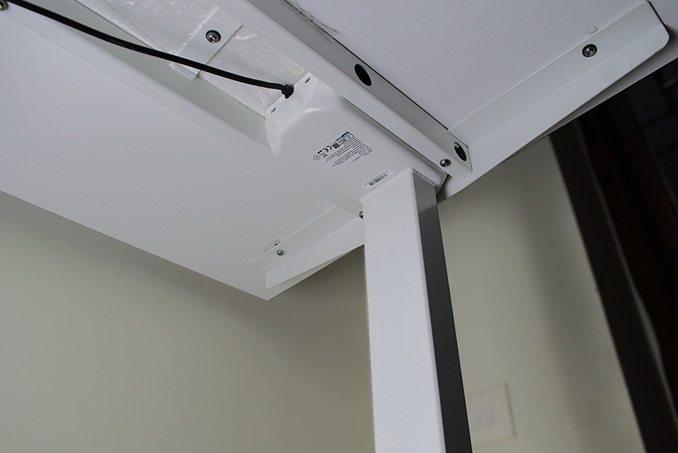 Electric motor beneath the standing desk