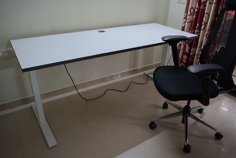 Standing desk setup next to an office chair