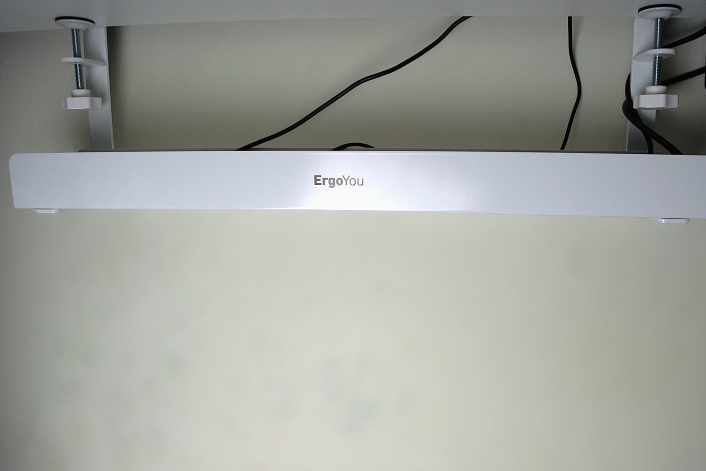 White under desk tray mounted to a standing desk with C-Clamp