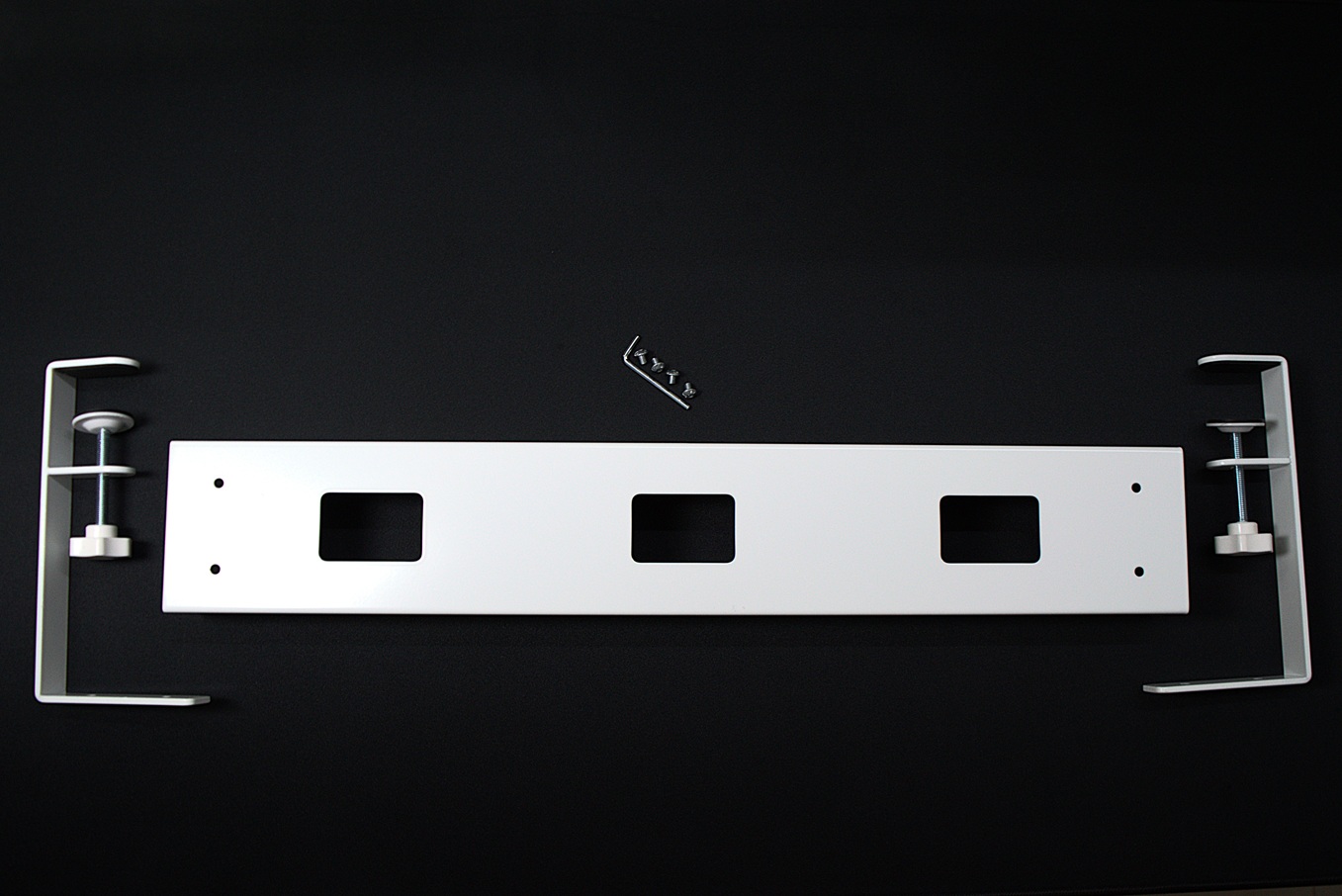 Parts of an under desk tray on a black desk mat